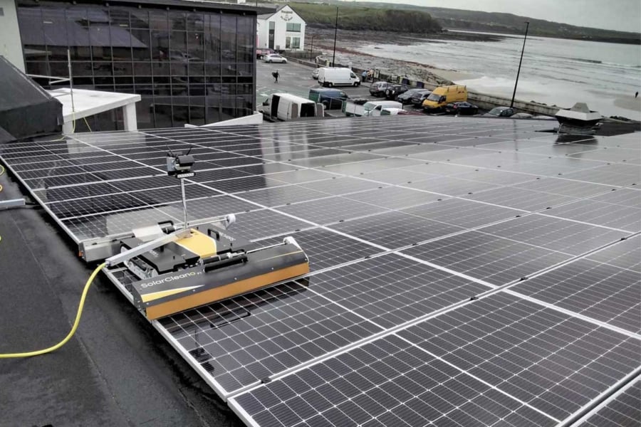 Robotic solar panel cleaning system at work on a commercial rooftop array